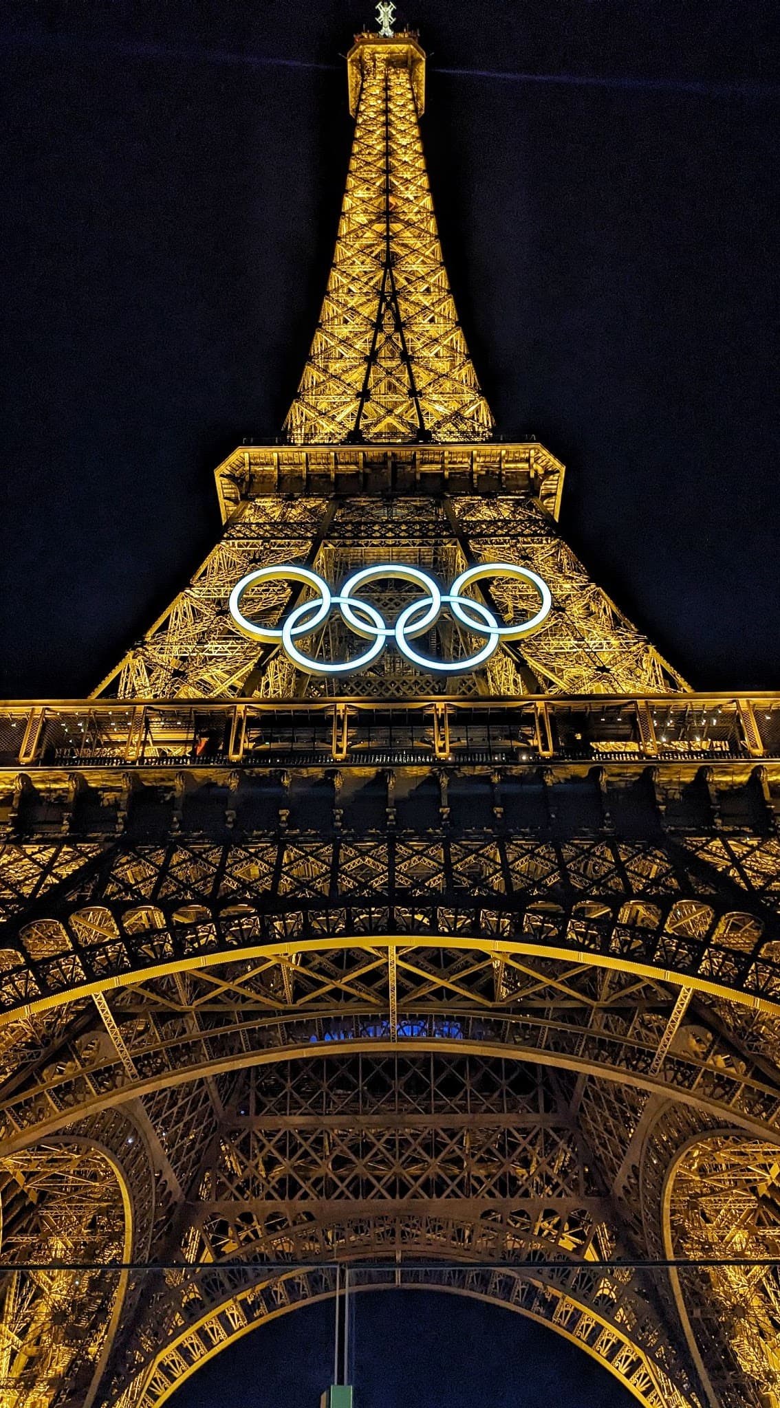 The nighttime Eiffel Tower decorated with the Olympic Rings