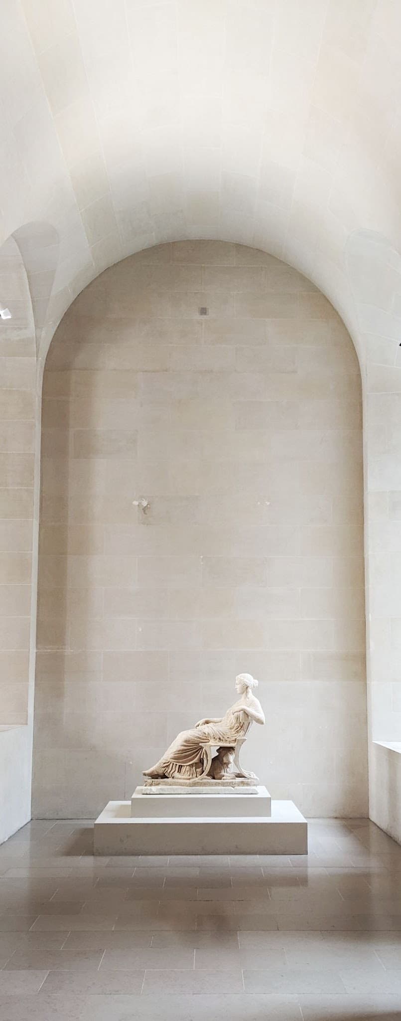 A marble woman in drapes relaxes under a clean quartz arch